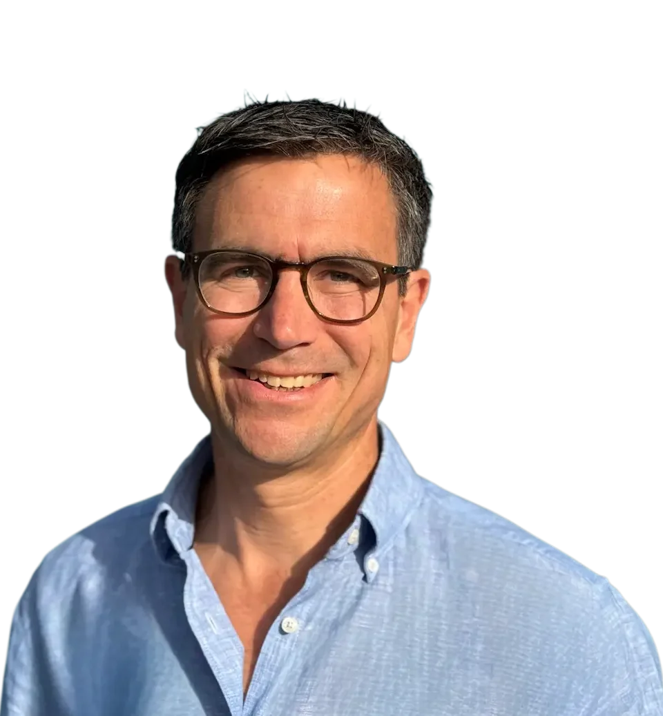Willkommen bei Dr. Christoph Prandstetter - ihr Kinderkardiologe Mann mit kurzen grau-schwarzen Haaren, Brille, in einem hellen Polohemd lächelt freundlich.